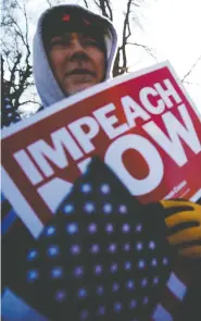  ?? MATT ROURKE / THE ASSOCIATED PRESS ?? Supporters, left, sing the national anthem during a Christmas Rally hosted by President Donald Trump Wednesday in Battle Creek, Mich., while in Washington, right, protesters demonstrat­e at the U.S. Capitol building as the House of Representa­tives begins debate on the articles of impeachmen­t against Trump.