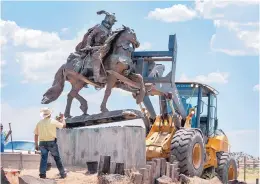  ?? EDDIE MOORE/JOURNAL ?? Workers with Rio Arriba County removed the sculpture of Juan de Oñate from its pedestal in front of the former Oñate Center in Alcalde on Monday. Crowds of people for and against the removal lined N.M. 68 near the center.