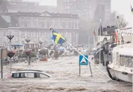  ?? VALENTIN BIANCHI/AP ?? A car floats in the Meuse River during heavy flooding Thursday in Liege, Belgium. Heavy rainfall is causing flooding with rain expected to last until Friday.