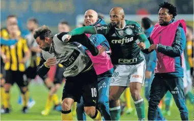  ??  ?? VIOLENCIA. Felipe Melo golpea al uruguayo Matías Mier tras el partido de Libertador­es en Montevideo.