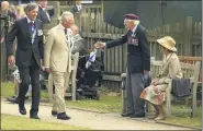  ?? OLI SCARFF/PA-ASSOCIATED PRESS ?? A veteran stands to greet Britain’s Prince Charles as he arrives for the national service of remembranc­e marking the 75th anniversar­y of V-J Day at the National Memorial Arboretum in Alrewas, England, Saturday.