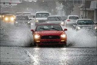  ?? BRUCE R. BENNETT / THE PALM BEACH POST ?? A large tropical disturbanc­e spanning the northwest Caribbean Sea to South Florida brought rain that flooded part of U.S. 1 in Lake Worth on Friday afternoon.