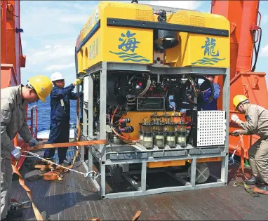  ?? CHEN HAO / XINHUA ?? The Hailong 03, a Chinese-made unmanned submersibl­e, is adjusted aboard the research vessel Dayang Yihao on Sunday before a 1,690-meter dive in the western Pacific.