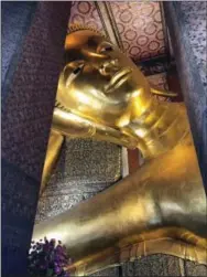  ?? COURTNEY BONNELL — THE ASSOCIATED PRESS ?? In this photo, a massive Buddha statue is the main attraction at Wat Pho, or the Temple of the Reclining Buddha, in Bangkok. The golden statue fills the temple from end to end and lies in a complex that boasts a series of opulent buildings and a school...
