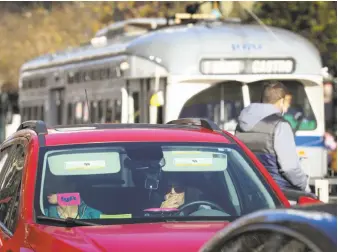  ?? Amy Osborne / Special to The Chronicle 2016 ?? A Lyft car travels on Market Street in San Francisco with an F-line streetcar behind it last year.