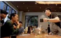  ?? JASON LEE / REUTERS ?? A barista serves coffee to a woman at a new Starbucks Reserve flagship store in Beijing’s Qianmen area on June 30.