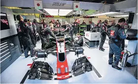  ??  ?? Hive of activity: Mechanics at work in the American Haas team’s garage