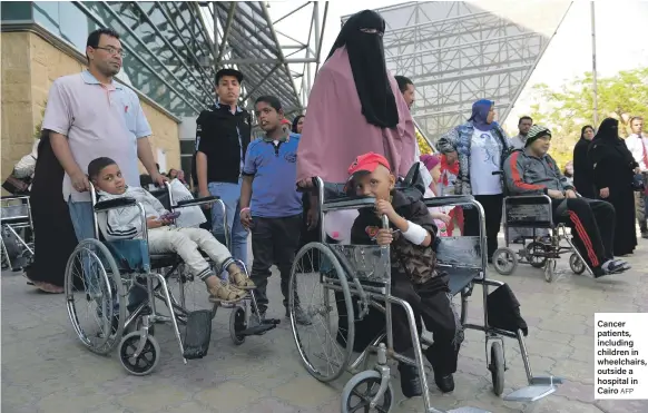  ?? AFP ?? Cancer patients, including children in wheelchair­s, outside a hospital in Cairo