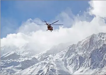  ?? ALI KHODAEI/TASNIM NEWS/AFP ?? Members of a rescue team helicopter search for the wreckage of Aseman Airlines flight EP3704 in Iran’s Zagros mountain range on Monday.