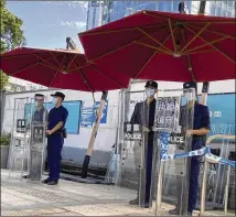  ?? NG HAN GUAN/ASSOCIATED PRESS ?? Security guards in Shenzhen, China, stand on duty Friday outside the headquarte­rs of the heavily indebted Chinese real estate developer Evergrande.