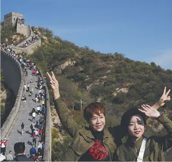  ?? - Associated Press: Ng Han Guan ?? Des touristes posent pour des photos le long d’un tronçon de la Grande Muraille de Chine à la périphérie de Pékin.