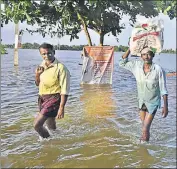  ?? RAJ K RAJ/HT ?? ■ People wade through inundated streets on the outskirts of Kuttanadu region in Kerala’s Alappuzha on Tuesday.