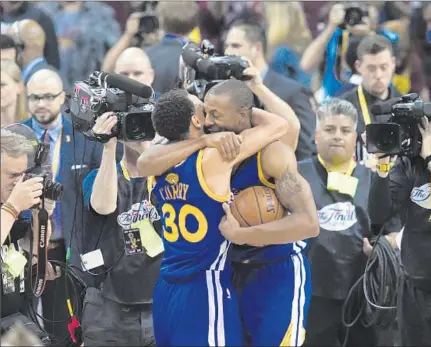  ?? Timothy A. Clary AFP/Getty Images ?? STEPHEN CURRY, the MVP of the regular season, and Andre Iguodala, the MVP of the Finals, embrace after the Warriors’ series-clinching victory over the Cavaliers. Iguodala averaged 16.3 points, 5.8 rebounds and played tough defense on LeBron James.