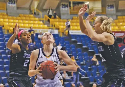  ?? STAFF PHOTO BY DOUG STRICKLAND ?? UTC guard Lakelyn Bouldin, center, shoots between Furman forwards Cierra Carter, left, and Kaitlyn Duncan during their SoCon game Thursday night at McKenzie Arena. Bouldin scored 18 points as the Mocs avenged a 65-48 loss to the Paladins last month in...