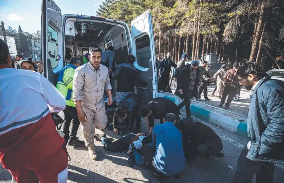  ?? ?? Iranian emergency workers treat the injured at the site of an explosion in a crowd marking the anniversar­y of the death of Qasem Soleimani. Pictures: AFP