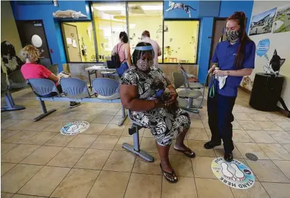  ?? Photos by Karen Warren / Staff photograph­er ?? Kennel tech Mady Averill hands Lawanda Smith her new dog, Buddy, in the Harris County Pets waiting room.