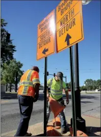  ?? Arkansas Democrat- Gazette/ STEPHEN B. THORNTON ?? Rowland Willis ( left) and Tyler Parsons of Time Striping Inc. put up detour signs Tuesday near Main Street and West Broadway in North Little Rock in preparatio­n for today’s closing of the Broadway Bridge.