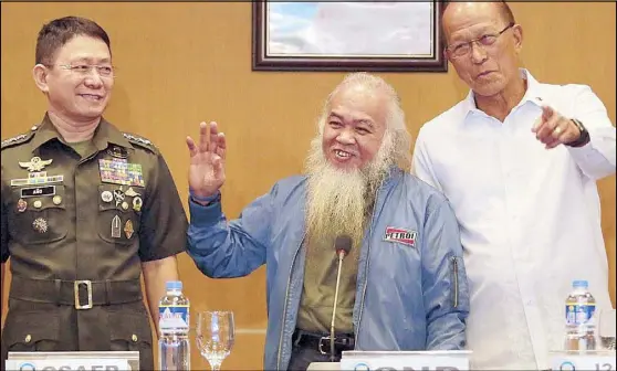  ?? MICHAEL VARCAS ?? Rescued Catholic priest Rey Teresito Soganub waves to reporters as he is presented in a news conference at Camp Aguinaldo yesterday. Joining him are Armed Forces chief Gen. Eduardo Año (left) and Defense Secretary Delfin Lorenzana. Story on Page 2.