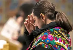  ?? ?? A congregant crosses herself during a service Wednesday to pray for peace in Ukraine at Holy Trinity Ukrainian Catholic Church.