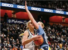  ?? Jessica Hill/Associated Press ?? UConn’s Dorka Juhasz, left, drives to the basket as Marquette’s Liza Karlen defends during the first half on Sunday.