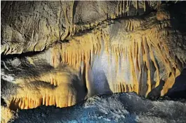  ??  ?? Arriba y al costado, tres imágenes de la Caverna de las Brujas: sus velos dorados, una gran estalagmit­a sobre el piso y la panorámica del valle desde la entrada. Der.: una arcada en la caminata hacia el Cerro Leones.