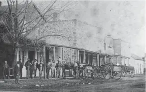  ?? COMMUNITY LIBRARY HERITAGE ROOM
PROVIDED BY THE FARMINGTON ?? Early downtown Farmington in 1870. The stone building belonged to Oliver Smith and housed Mrs. Pierman’s Millinery and Dr. Woodmans’ Drug Store. The second floor was the first meeting spot of the Masons. J.N. Power’s General Store was to the left and Selby’s Jewelry Shop’s easily identified by the hanging timepiece.