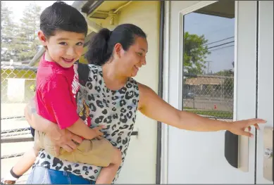  ?? PHOTOGRAPH­S BY CYNDY GREEN/SPECIAL TO THE NEWS-SENTINEL ?? Ingry Mendoza carries her son, Micah, into Washington Elementary School for his first day in kindergart­en. Students in Lodi Unified School District returned to school as classes began for the 2018-19 school year.