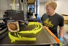  ?? Darrell Sapp/Post-Gazette ?? Ryan Priore watches as two 3D printers make frames for face shields in Cranberry.