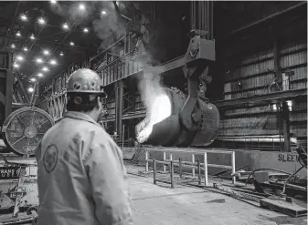  ?? Jeff Roberson / Associated Press ?? Senior melt operator Randy Feltmeyer watches a giant ladle as it backs away after pouring red-hot iron into a vessel at the U.S. Steel Granite City Works facility in Granite City, Ill.