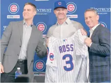  ?? /JAVIER QUIROZ / LA RAZA ?? David Ross recibe la camiseta y gorra de los Cachorros de parte del Presidente Theo Epstein y del vicepresid­ente Jed Hoyer.