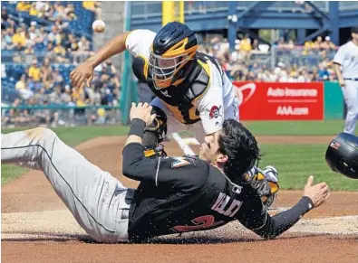  ?? GENE J. PUSKAR/AP ?? Miami Marlins outfielder Christian Yelich, front, scores on a double by Marcell Ozuna as the ball gets away from Pittsburgh Pirates catcher Elias Diaz during the first inning of their game in Pittsburgh on Saturday.