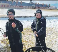  ?? DAVID JALA/CAPE BRETON POST ?? Owen Mahon, left, samples his roasted marshmallo­w while Bretton Crysler puts the finishing touches on his treat during a break from skating at the Fortress of Louisbourg on Sunday. Hot chocolate was also offered up to the more than 600 people who took...