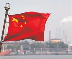  ?? JOHANNES EISELE / AFP / Gett y Imag es ?? A Chinese flag flutters in front of an oil refinery in Shanghai. As China’s share of fuel consumptio­n has
grown, so has its share of refining capacity.