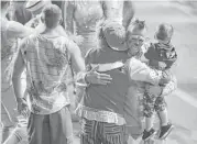  ?? Julie Jacobson / Associated Press ?? Boss clown Sandor Eke, holding his 2-year-old son, embraces fellow clowns after the red unit’s final performanc­e earlier this month in Providence, R.I.