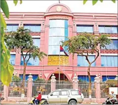  ?? PHA LINA ?? Traffic passes in front of National Bank of Cambodia headquarte­rs in Phnom Penh. The banking body raised its annual growth forecast for this year after several positive economic signals.