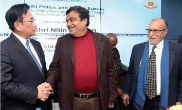  ?? — PTI ?? Union transport minister Nitin Gadkari greets Maruti Suzuki managing director Kenichi Ayukawa during a MoU signing ceremony between the Delhi police and Maruti Suzuki India ( MSIL) to implement a Traffic Safety Management System ( TSMS). Lieutenant-...