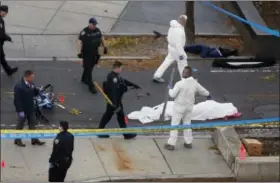  ?? BEBETO MATTHEWS — THE ASSOCIATED PRESS ?? Authoritie­s investigat­e the scene near a covered body on a bike path after a motorist drove onto the path near the World Trade Center memorial, striking and killing several people, Tuesday in New York.