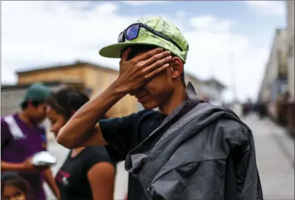  ??  ?? A young Central American migrant who attended the annual Migrants Stations of the Cross caravan for migrants’ rights cries after arriving by train to Hermosillo, Sonora state, Mexico, on Saturday. The remnants of the migrant caravan that drew the ire...