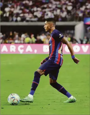  ?? Ethan Miller / Getty Images ?? Barcelona’s Raphinha dribbles the ball against Real Madrid during their preseason friendly match at Allegiant Stadium on July 23 in Las Vegas.