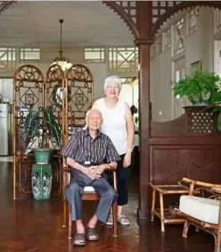  ??  ?? Louise Clarke (standing) and her father, Gerard Clarke, in the bungalow’s living room featuring the traditiona­l handcarved wooden screen.