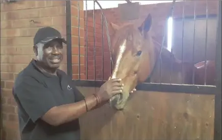  ??  ?? Bulana Bennett, the only black horse trainer in South Africa, with one of his horses at the Gold Circle training facility in Ashburton, where he recently reopened a training yard.