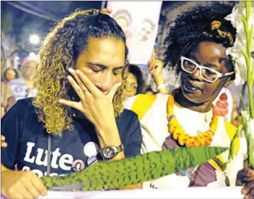  ?? DIEGO HERCULANO/AFP ?? Anielle Silva (left), sister of activist Marielle Franco, cries at a memorial in Rio de Janeiro on April 14, one month after her murder in Lapa.
