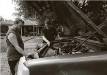  ??  ?? Johnson gets help from his brother Jonathan rather than pay a mechanic to fix the thermostat of his truck Thursday.