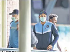  ?? GETTY IMAGES ?? Rohit Sharma (C) with the Indian support staff wearing masks as they enter the dressing room.