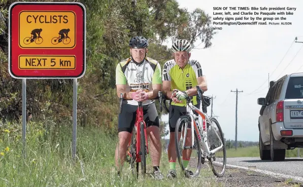  ?? WYND Picture: ALISON ?? SIGN OF THE TIMES: Bike Safe president Garry Laver, left, and Charlie De Pasquale with bike safety signs paid for by the group on the Portarling­ton/Queensclif­f road.