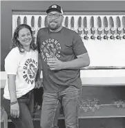  ?? PHOTO PROVIDED ?? Entreprene­urial couple Bobbi Gabler, left, director of operations, and Jake Keyes, CEO and founder, stand in front of the taproom faucets at Skydance Brewing Co., Oklahoma's first Native American-owned brewery, which opened its new location Saturday.