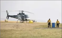  ?? @TMartinHer­ald Herald photo by Tijana Martin ?? Members of the Government of Alberta's Wildfire Management team take a break from battling the Kenow wildfire after landing at the Pincher Creek Airport on Tuesday.