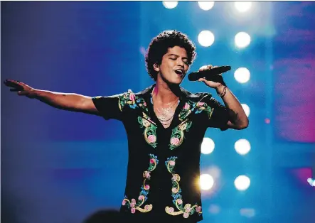  ?? THE CANADIAN PRESS ?? Bruno Mars, who performed on the Apollo Theater marquee while recording his new special, picked up six Grammy nods Tuesday.