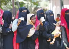  ?? (Mohammad Ponir Hossain/Reuters) ?? ROHINGYA WOMEN wait in a line with vouchers to collect relief distribute­d by the Bangladesh Red Crescent Society at the Kutupalang Unregister­ed Refugee Camp in Cox’s Bazar, Bangladesh, on Monday.