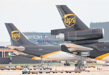  ?? Tony Gutierrez / Associated Press ?? A UPS aircraft is set for unloading at D-FW Internatio­nal Airport. United Parcel Service also has announced that starting Jan. 1, it will offer pickup and delivery services seven days a week, adding service on Sundays.